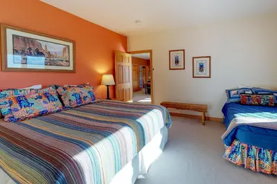 a bedroom with two beds and an orange wall at Aspen View in Silverthorne