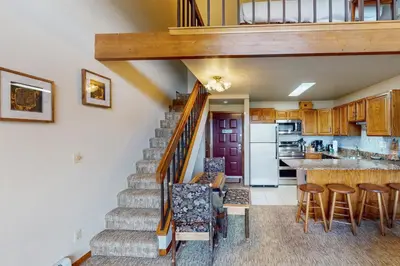 a staircase leading up to a kitchen with a dining room at Buffalo Village 402 in Silverthorne
