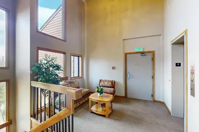 a hallway of a building with a door and a chair at Buffalo Village 402 in Silverthorne