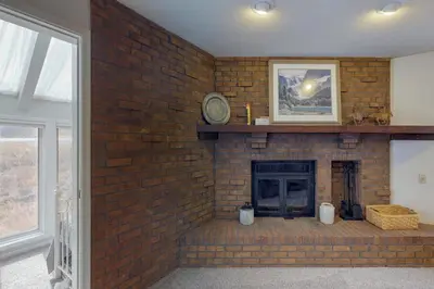 a brick wall with a fireplace in a living room at Alpine Getaway in Gold Hill