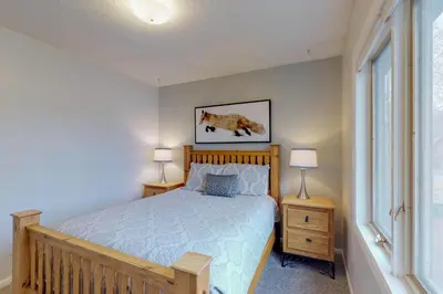 a bedroom with a bed and two lamps and a window at Alpine Getaway in Gold Hill