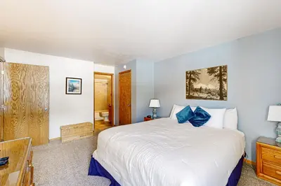 a bedroom with a large white bed with blue pillows at Buffalo Village 306 in Silverthorne