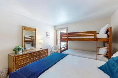 a bedroom with two bunk beds and a mirror at Buffalo Village 306 in Silverthorne