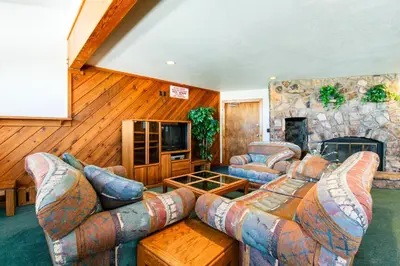 a living room with couches and a stone fireplace at Buffalo Village 306 in Silverthorne
