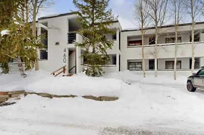 a building covered in snow with a car parked in front at East Bay 6 in Dillon