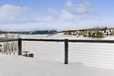a fence covered in snow with mountains in the background at East Bay 6 in Dillon