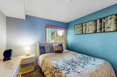 a bedroom with a blue wall with a bed and a desk at Watch Hill in Silverthorne