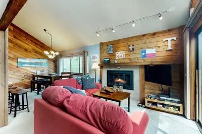 a living room with a red couch and a fireplace at Blue River Rendezvous in Silverthorne
