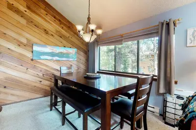 a dining room with a table and chairs and a window at Blue River Rendezvous in Silverthorne
