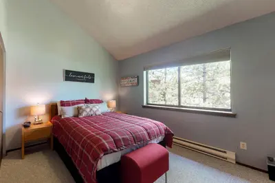 a bedroom with a bed with a red blanket and a window at Blue River Rendezvous in Silverthorne