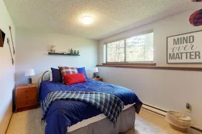 a bedroom with a bed with a blue comforter and a window at Blue River Rendezvous in Silverthorne