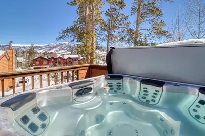 a jacuzzi tub on the deck of a house at Blue River Rendezvous in Silverthorne