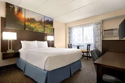 a hotel room with a large bed and a desk at Days Inn by Wyndham Fort Collins in Fort Collins