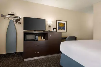 a hotel room with a bed and a flat screen tv at Days Inn by Wyndham Fort Collins in Fort Collins
