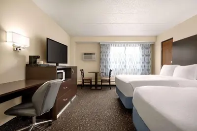 a hotel room with two beds and a desk at Days Inn by Wyndham Fort Collins in Fort Collins