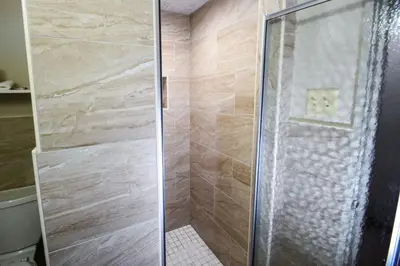 a shower with a glass door in a bathroom at Belcaro Motel in Denver