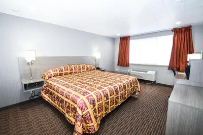 a hotel room with a bed and a window at Belcaro Motel in Denver