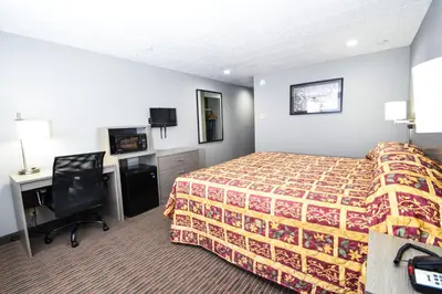 a hotel room with a bed and a desk at Belcaro Motel in Denver