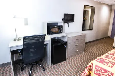 a hotel room with a desk with a computer and a television at Belcaro Motel in Denver