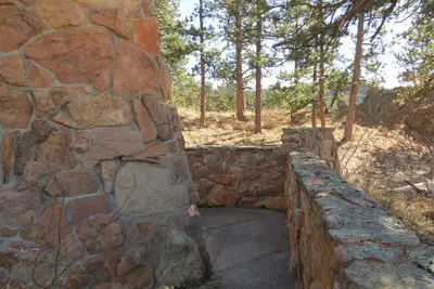 a stone retaining wall with a stone wall at Stutzhaven In The Mountains Home in Estes Park