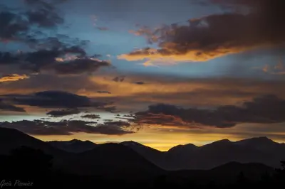 a sunset with mountains in the background at Stutzhaven In The Mountains Home in Estes Park
