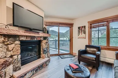 a living room with a fireplace with a flat screen tv at 8619 Expedition Station Condo in Keystone