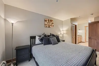 a bedroom with a large bed with blue pillows at 8619 Expedition Station Condo in Keystone