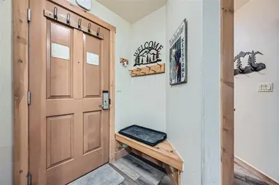 a door in a hallway with a bench next to it at 8619 Expedition Station Condo in Keystone