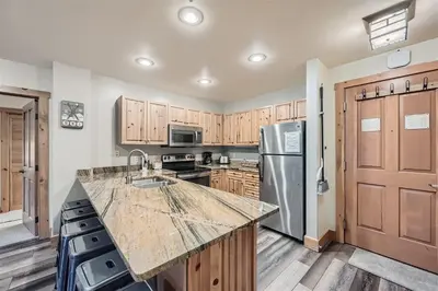 a kitchen with wooden cabinets and a granite counter top at 8619 Expedition Station Condo in Keystone