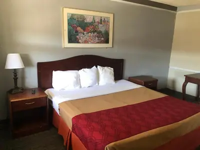 a hotel room with a bed with a red blanket at Americas Best Value Inn Denver in Denver