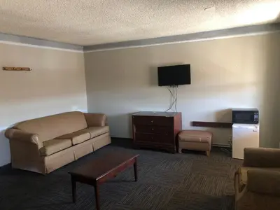 a living room with a couch and a tv at Americas Best Value Inn Denver in Denver
