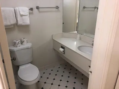a bathroom with a toilet and a sink and a mirror at Americas Best Value Inn Denver in Denver
