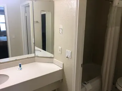 a bathroom with a sink and a toilet and a mirror at Americas Best Value Inn Denver in Denver