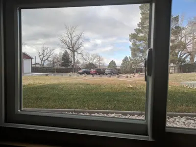 a window view of a yard with cars parked in a field at DIA BnB - We love workers in Brighton