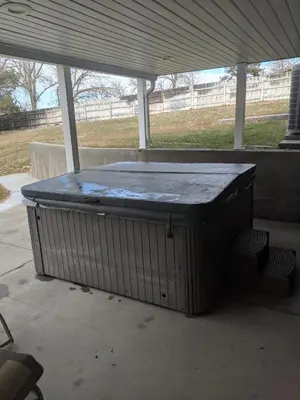 a hot tub sitting under a covering on a patio at DIA BnB - We love workers in Brighton