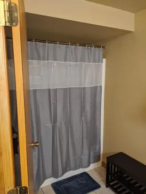 a shower curtain in the corner of a room at DIA BnB - We love workers in Brighton