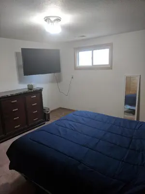 a bedroom with a blue bed and a flat screen tv at DIA BnB - We love workers in Brighton