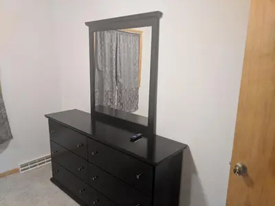 a black dresser with a mirror on top of it at DIA BnB - Mountain View - Private floor - DIA Layover - Great entertainment and bed in Brighton