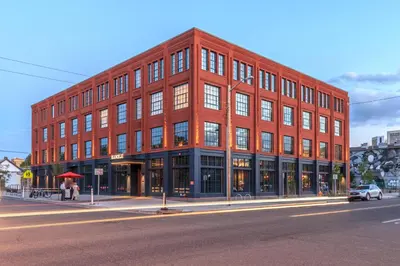 a large red brick building on a city street at The Ramble Hotel in Denver