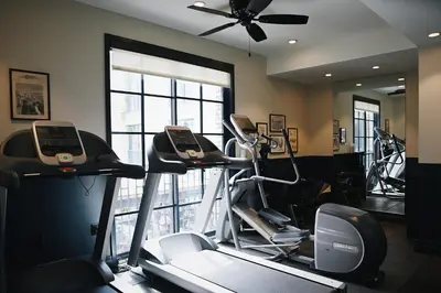 a gym with several exercise bikes and a ceiling fan at The Ramble Hotel in Denver