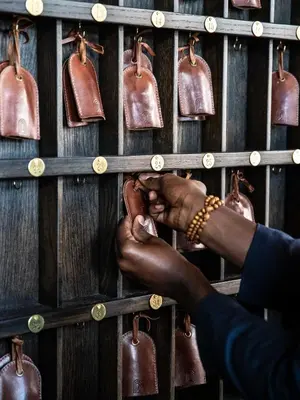a person holding onto a rack of leather bags at The Ramble Hotel in Denver