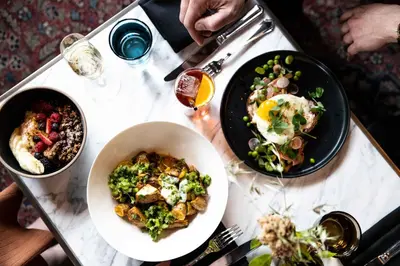 a table with two plates of food on it at The Ramble Hotel in Denver