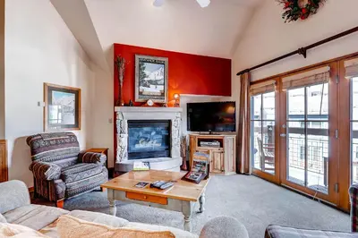 a living room with a fireplace and a tv at Jackpine 8021 in Keystone