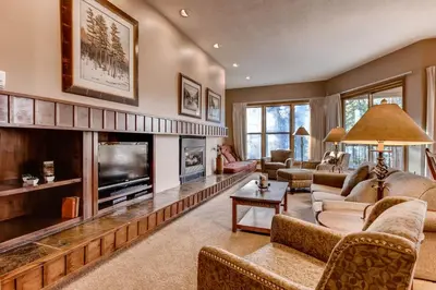 a living room with a large fireplace and a tv at Quicksilver 1662 in Keystone