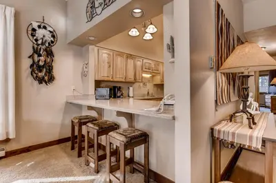 a kitchen with a counter and stools in a room at Quicksilver 1662 in Keystone