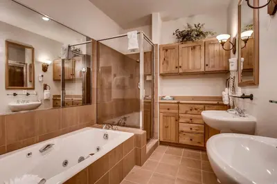 a large bathroom with a tub and a sink and a tubermott at Ski Tip Townhomes 8713 in Keystone