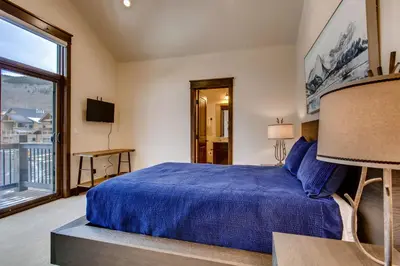 a bedroom with a blue bed and a large window at River Run Townhome RR38 in Keystone
