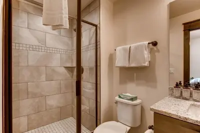 a bathroom with a shower and a toilet and a sink at River Run Townhome RR42 in Keystone