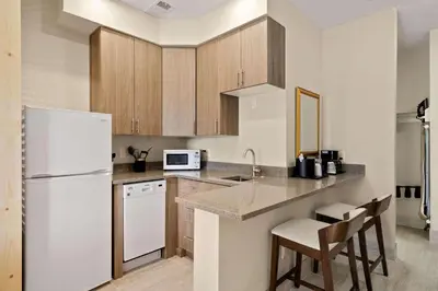 a kitchen with a white refrigerator and wooden cabinets at Country Inn & Suites by Radisson, Greeley, CO in Greeley