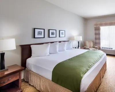 a hotel room with a large bed and a window at Country Inn & Suites by Radisson, Greeley, CO in Greeley